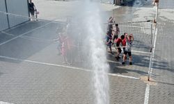 Hatay'da konteyner kentteki öğrenciler itfaiyenin sıktığı suyla serinledi