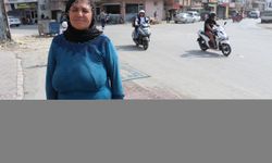 Adana'da tozdan rahatsız olan kadın yoldaki çukurları halıyla kapattı