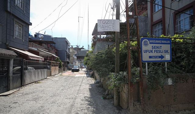 Adana'da mahalle sakinleri asfaltlanmayan yoldaki çukurları halılarla kapattı