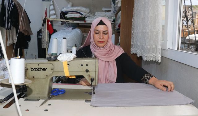Kadın muhtar mahallelinin hem derdini dinliyor hem terziliğini yapıyor