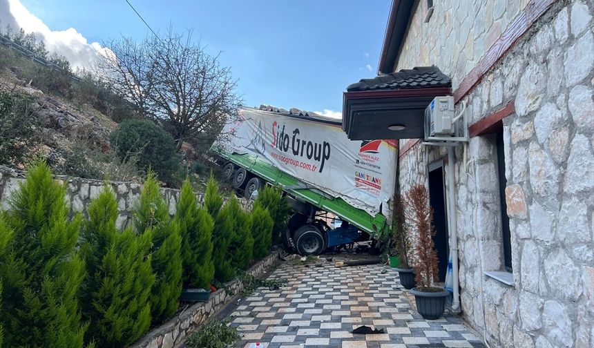 Antalya'da şarampole devrilen tırın bir eve çarparak durabildiği kazada sürücü yaralandı